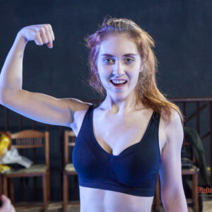 Akela flexing her bicep for the viewers